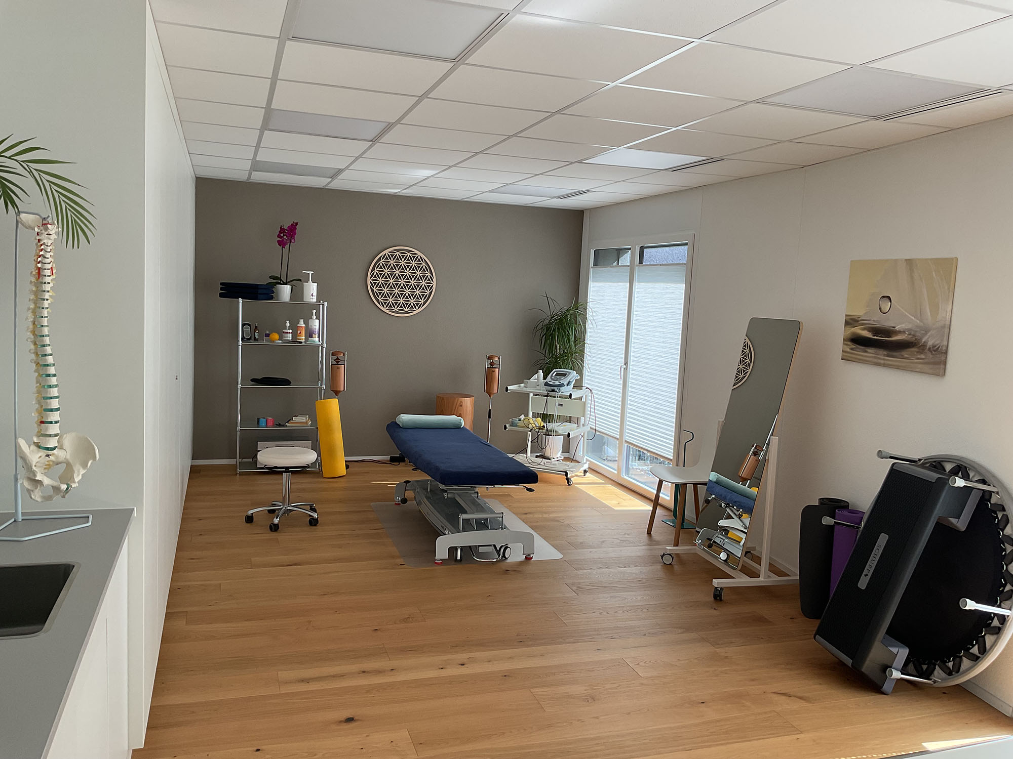 Ein Physiotherapie-Praxisraum mit Behandlungsliege und Trainingsgeräten.